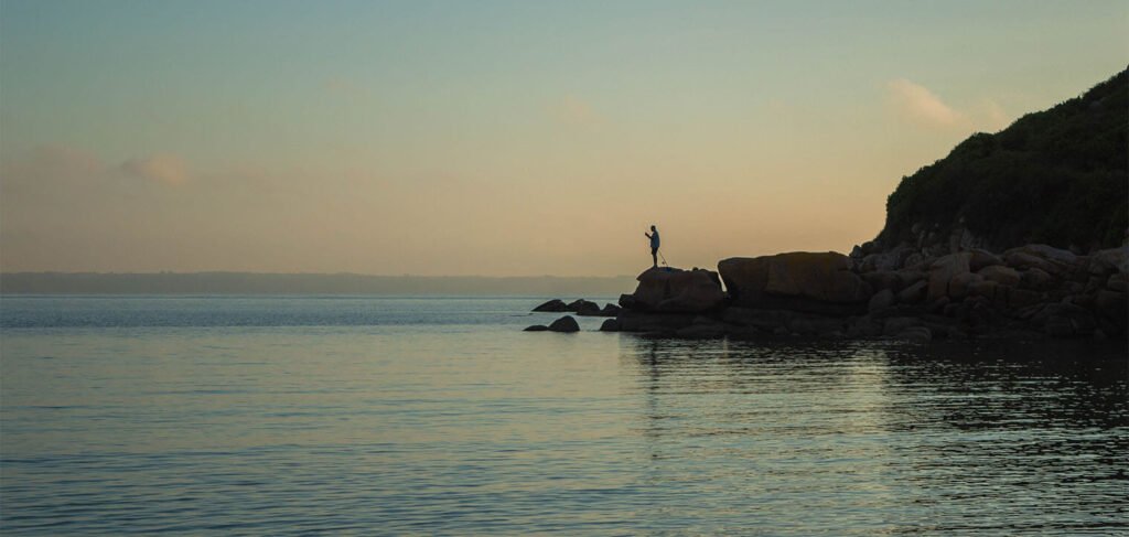 homme qui pêche au coucher du soleil